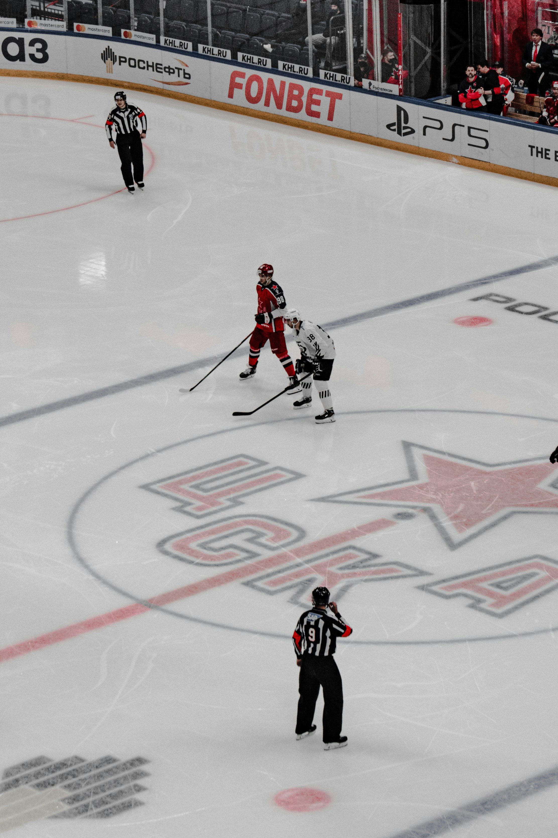 2 men playing hockey on ice field